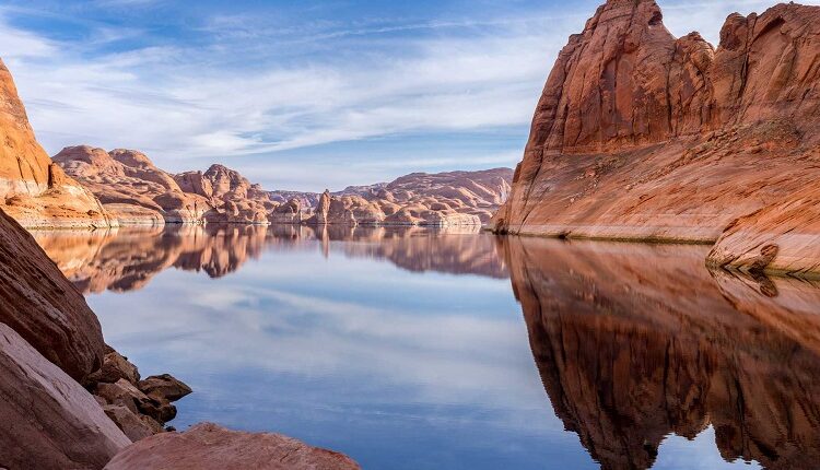 Red rock cliff reflection on water of Lake Powell